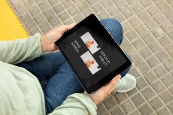 موکاپ صفحه نمایش تبلت در دستان یک بزرگسال در خیابان